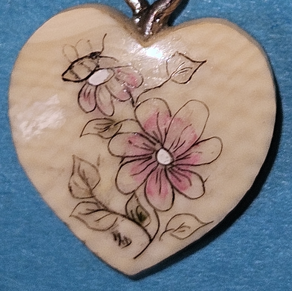 Delicate Painted flowers on heart looks like ivory but who knows.